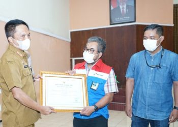 Area Manager Commrel & CSR PT KPI RU IV, Cecep Supriyatna menerima penghargaan TJSLP 2022 Cilacap dari Sekda Cilacap, Awaluddin Muuri. (ISTIMEWA)