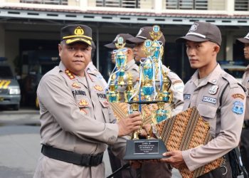 Kapolresta Cilacap KombesPol Fannky Ani Sugiharto menyerahkan piala dan piagam penghargaan kepada anggota Satpam berprestasi saat upacara HUT Satpam ke-42 di halaman Mapolresta setempat. (ISTIMEWA)