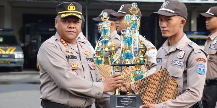 Kapolresta Cilacap KombesPol Fannky Ani Sugiharto menyerahkan piala dan piagam penghargaan kepada anggota Satpam berprestasi saat upacara HUT Satpam ke-42 di halaman Mapolresta setempat. (ISTIMEWA)