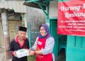 Pemilik warung yang ditunjuk Alfamart menyalurkan paket buka puasa kepada salah seorang warga kurang mampu. (ISTIMEWA)
