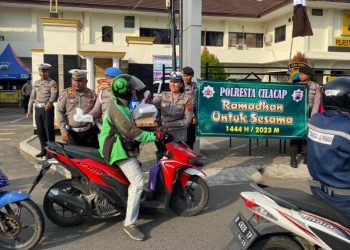 Anggota Polresta Cilacap membagikan takjil gratis kepada pengguna jalan yang melintas di depan Mapolresta. (ISTIMEWA)