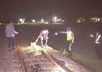 Petugas mengevakuasi tubuh korban yang tewas tertabrak KA Mutiara Selatan di Desa Kesugihan Kidul. (ISTIMEWA)