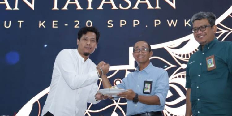 Ketua Umum SPP-PWK Cilacap Titok Dalimunthe menyerahkan potongan tumpeng syukuran 20 tahun SPPPWK kepada GM PT KPI RU IV Cilacap. (ISTIMEWA)