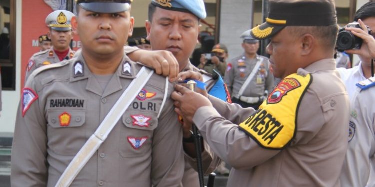 Kapolresta Cilacap memasang pita kepada perwakilan personel yang bakal diterjunkan dalam Operasi Patuh Candi 2023. (ISTIMEWA)