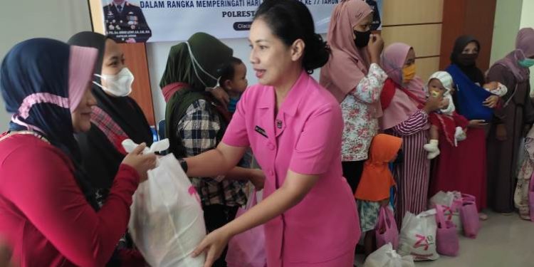 Ketua Bhayangkari Cabang Kota Cilacap menyerahkan bantuan kepada ibu-ibu dalam baksos pelayanan KB Bhayangkara dan percepatan penurunan stunting di Puskesmas 1 Kesugihan. (ISTIMEWA).