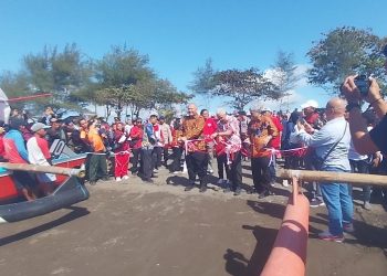 Gubernur Jawa Tengah Ganjar Pranowo bersama GM PLN Unit Induk Distribusi Jawa Tengah dan D.I. Yogyakarta didampingi Direktur Pemasaran dan Pengembangan PLN Enjiniring saat menggunting pita peluncuran kapal bermotor listrik berbasis baterai di Pantai Teluk Penyu, Cilacap. (Wagino/CILACAPMEDIA.com)