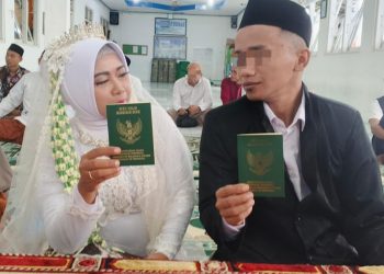 R bersama pasangannya senyum Bahagia seraya menunjukkan buku nikah usai resmi melangsungkan pernikahan di dalam Lapas Kelas II B Cilacap. (ISTIMEWA)