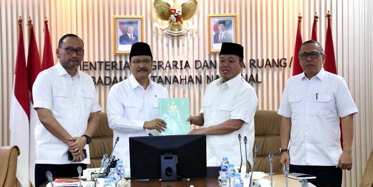 Menteri Sosial Saifullah Yusuf menyerahkan dokumen laporan perkembangan Sekolah Rakyat kepada Menteri Nusron. (ISTIMEWA)