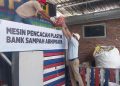 Direktur Operasi PT KPI, Didik Bahagia mengangkat sampah plastik bekas yang telah dipilah kepada operator untuk dimasukan mesin pencacah plastik. (FOTO : CILACAPMEDIA/Wagino)