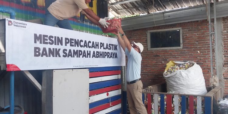 Direktur Operasi PT KPI, Didik Bahagia mengangkat sampah plastik bekas yang telah dipilah kepada operator untuk dimasukan mesin pencacah plastik. (FOTO : CILACAPMEDIA/Wagino)